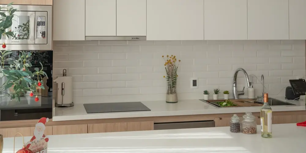 Cocina integral moderna con alacenas blancas y cubierta blanca en Querétaro — Casa Iktan