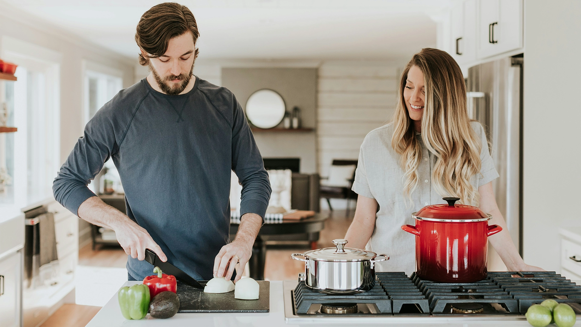 Dos personas preparando alimentos simultáneamente en una cocina