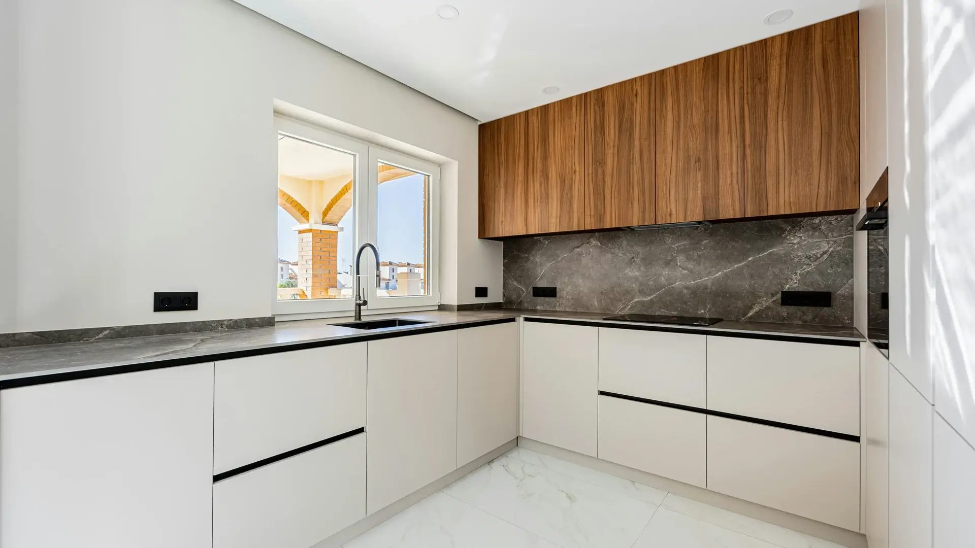 Cocina en L con gabinetes blancos y acabados de madera