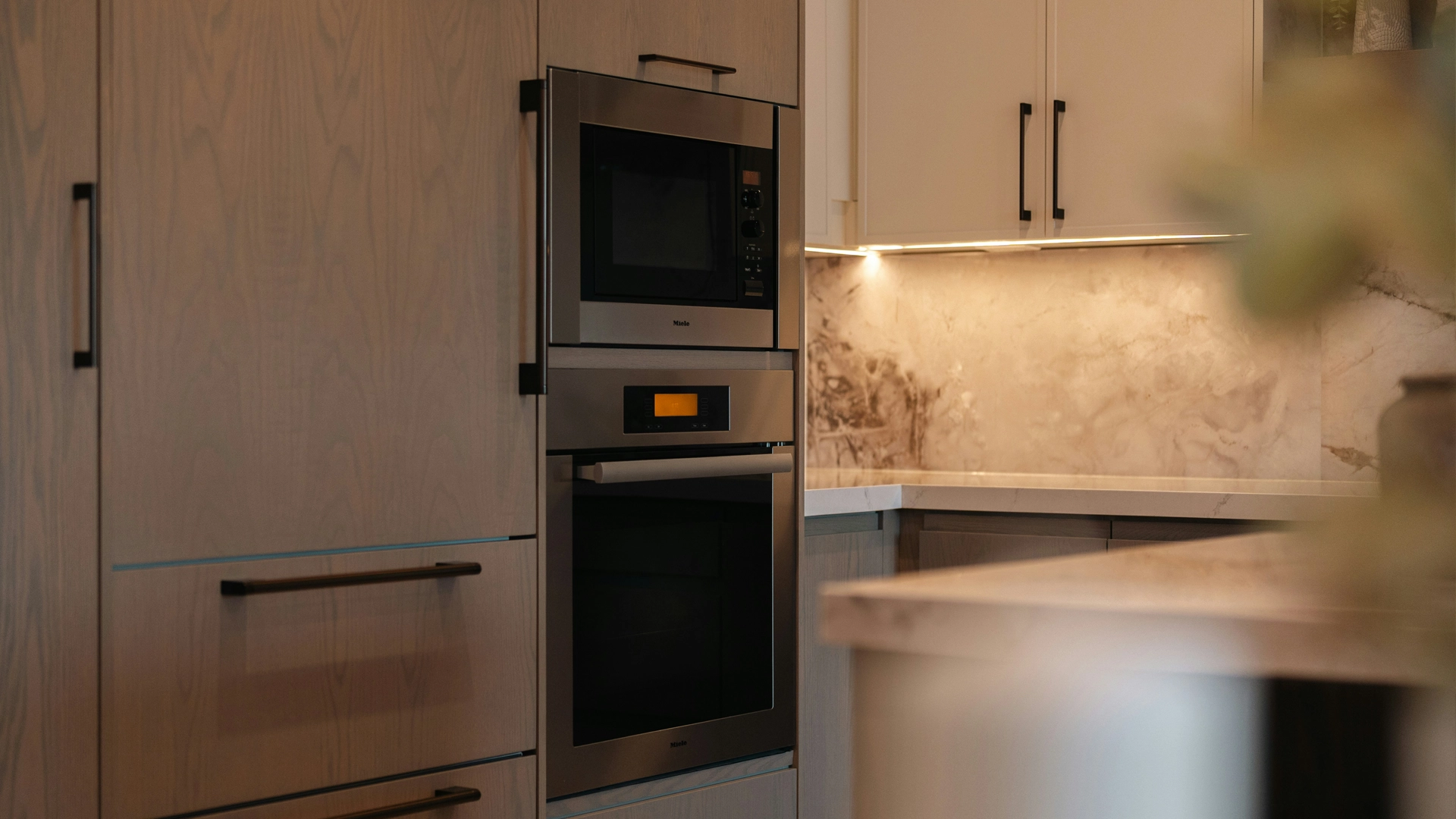 Torre de hornos con horno y microondas integrados en una cocina moderna