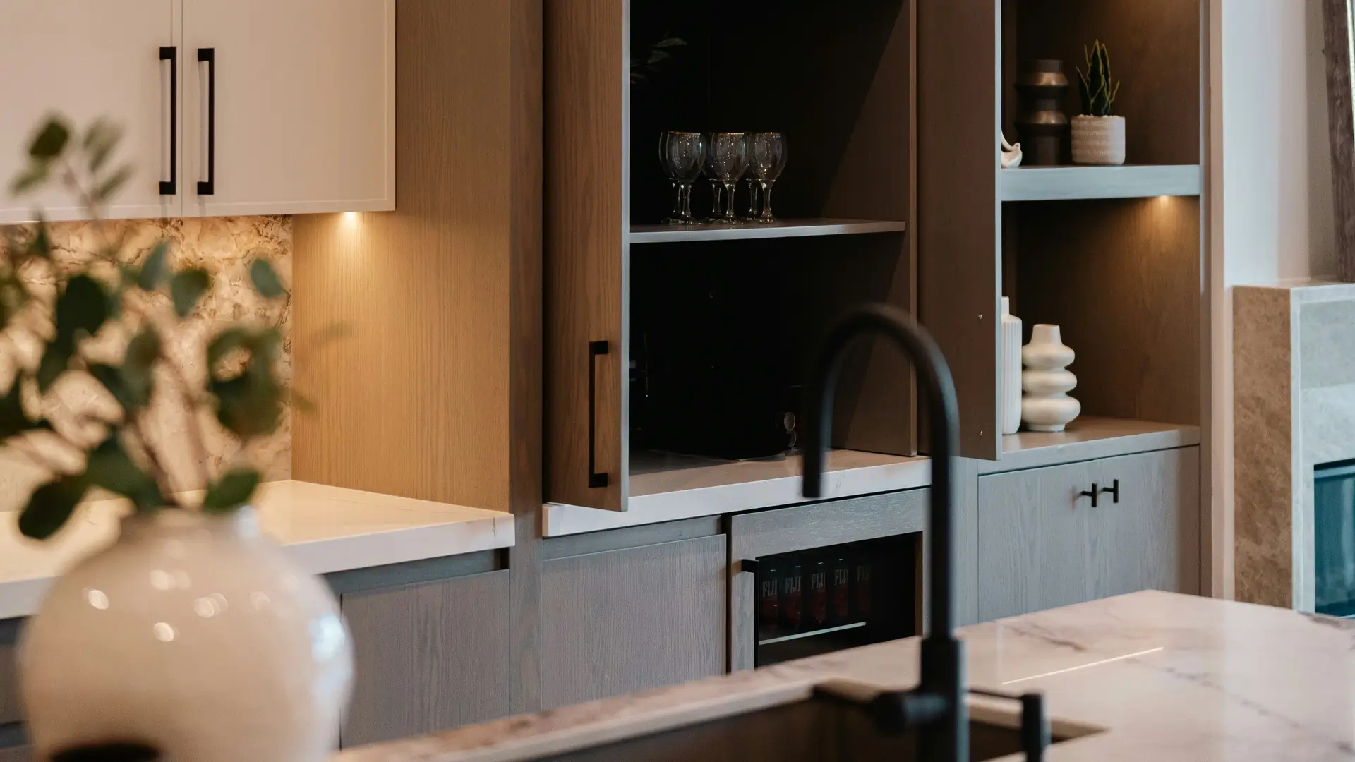 Cocina con isla, tarja y estantes que muestran distintas zonas de almacenamiento