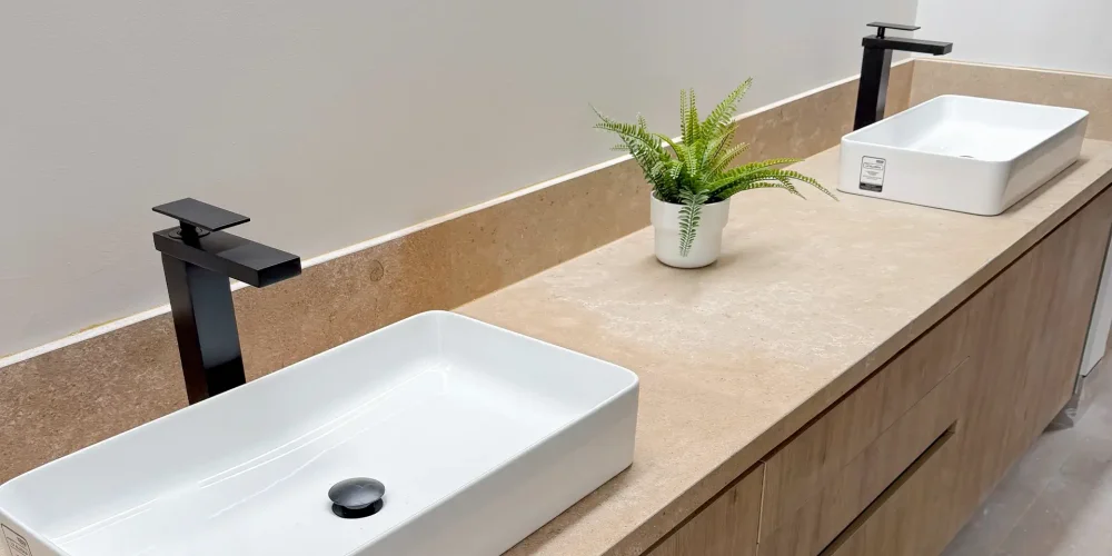 Detalle de vanity doble con lavabos sobre cubierta, grifería negra mate y mueble en acabado madera, con cubierta continua tipo piedra — Casa Iktan Querétaro